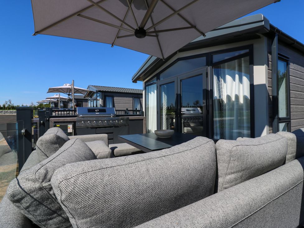 An outdoor seating area with a sofa and table at Lakewood Plot 5 St. Osyth
