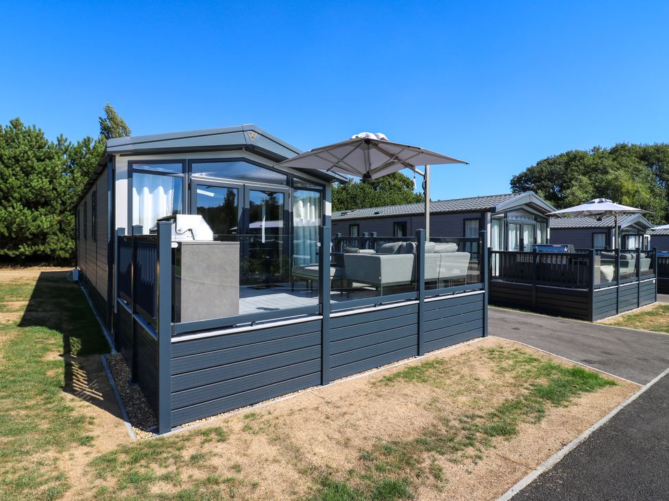 An outdoor area with a holiday home and deck at Lakewood Plot 5 St. Osyth