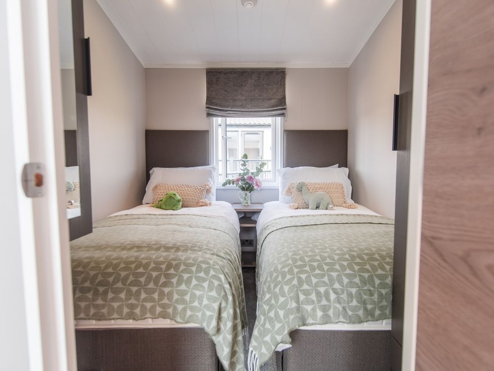 A bedroom with two beds and a window at Lakewood Plot 5 St. Osyth