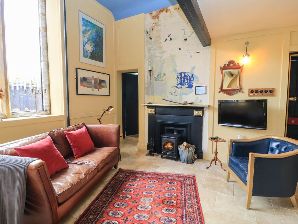 A living room with a sofa and an armchair at The Sunday School Room in Sherborne