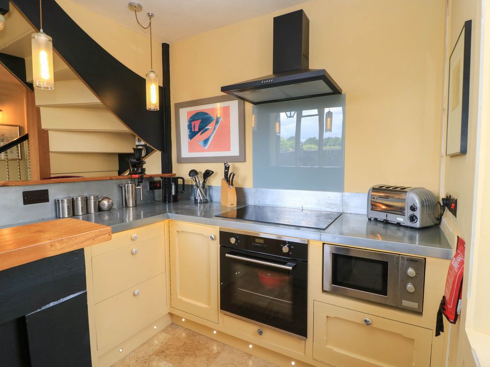 A kitchen with a stove and cabinets at The Sunday School Room in Sherborne