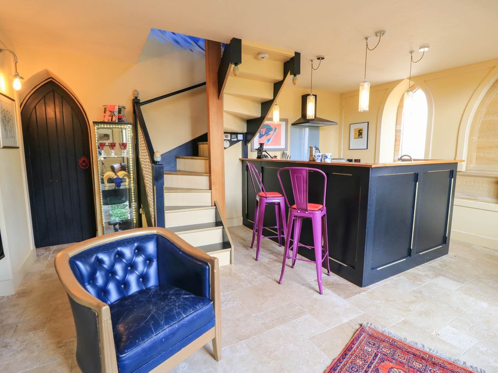 A kitchen with a bar counter and stools at The Sunday School Room in Sherborne