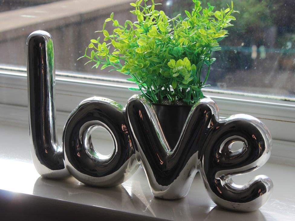 A decorative object with the word love and a plant at Oliver Wests Apartment 1 Scarborough