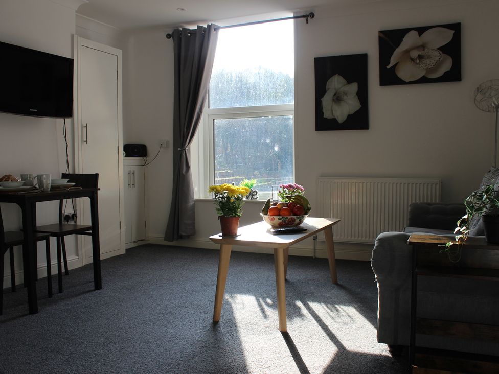 A living room with a tv and table at Oliver Wests Apartment 1 in Scarborough