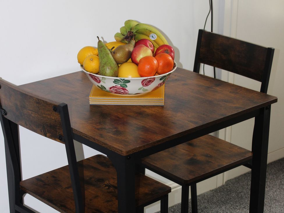 A dining room table with a bowl of fruits at Oliver Wests Apartment 1 Scarborough