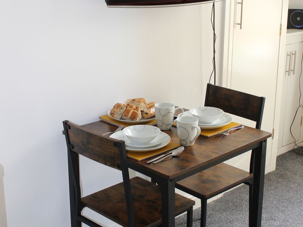 A small dining table set with plates and cups at Oliver Wests Apartment 1 in Scarborough