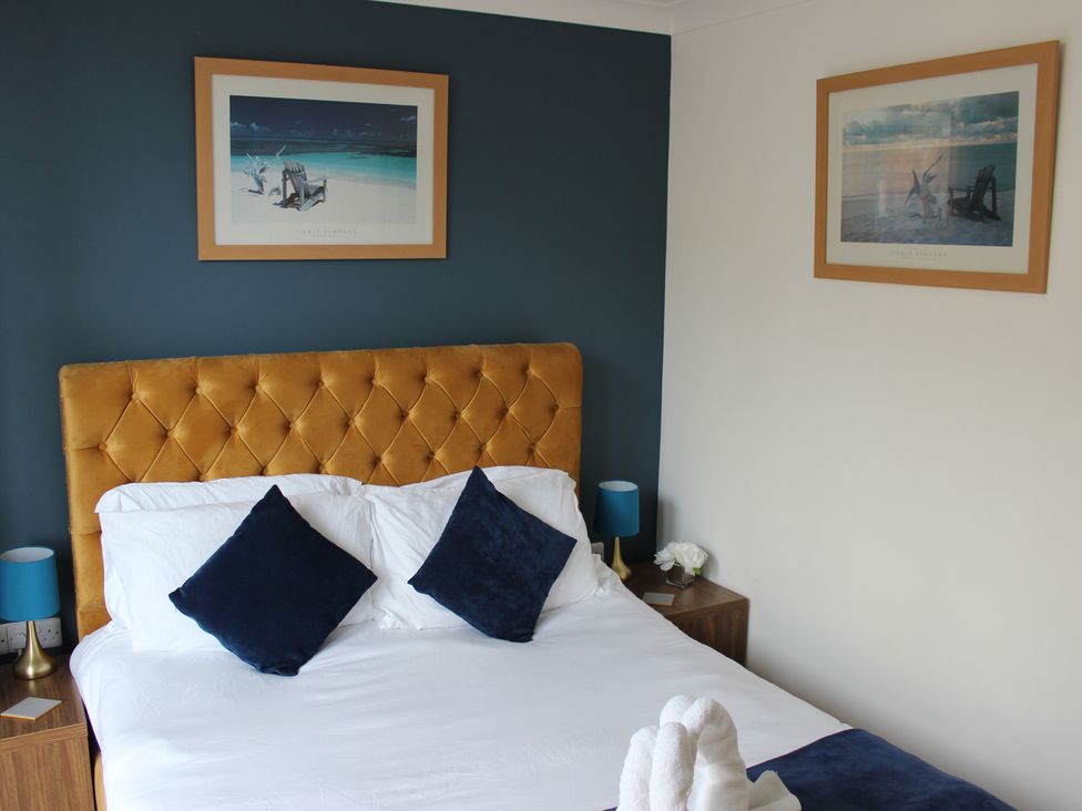 A bedroom with a bed and pictures on the wall at Oliver Wests Apartment 1 in Scarborough