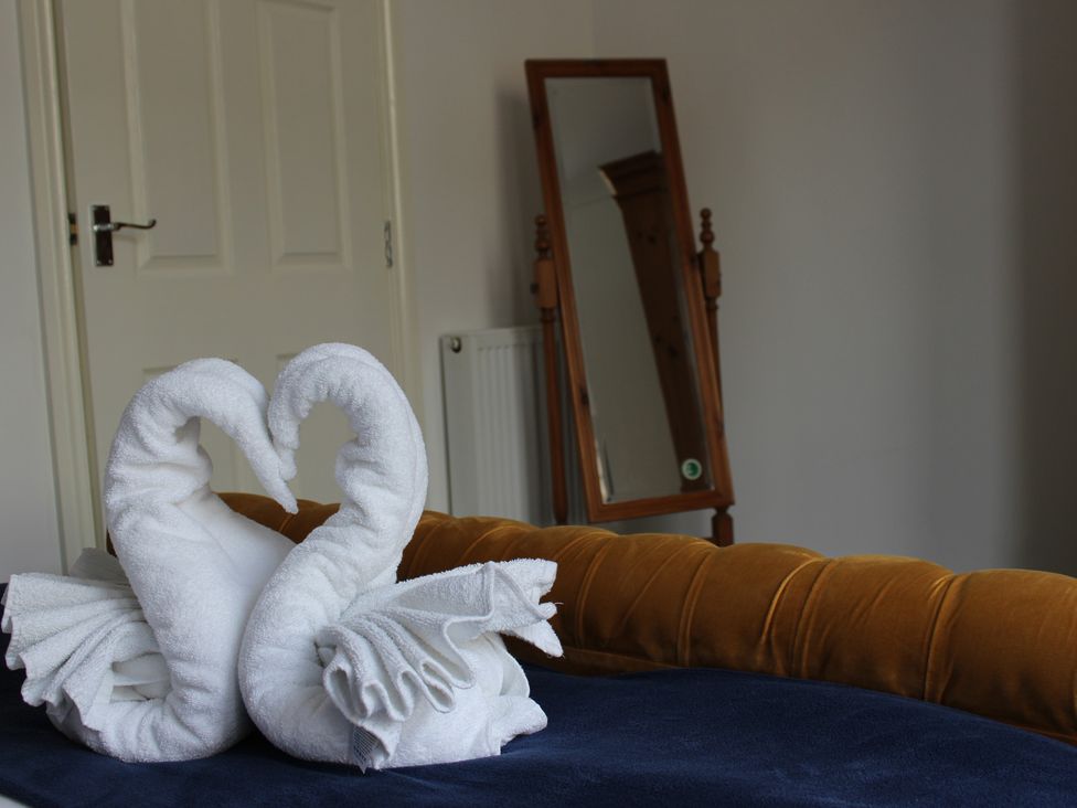 A bedroom with towels arranged as swans at Oliver Wests Apartment 1 in Scarborough