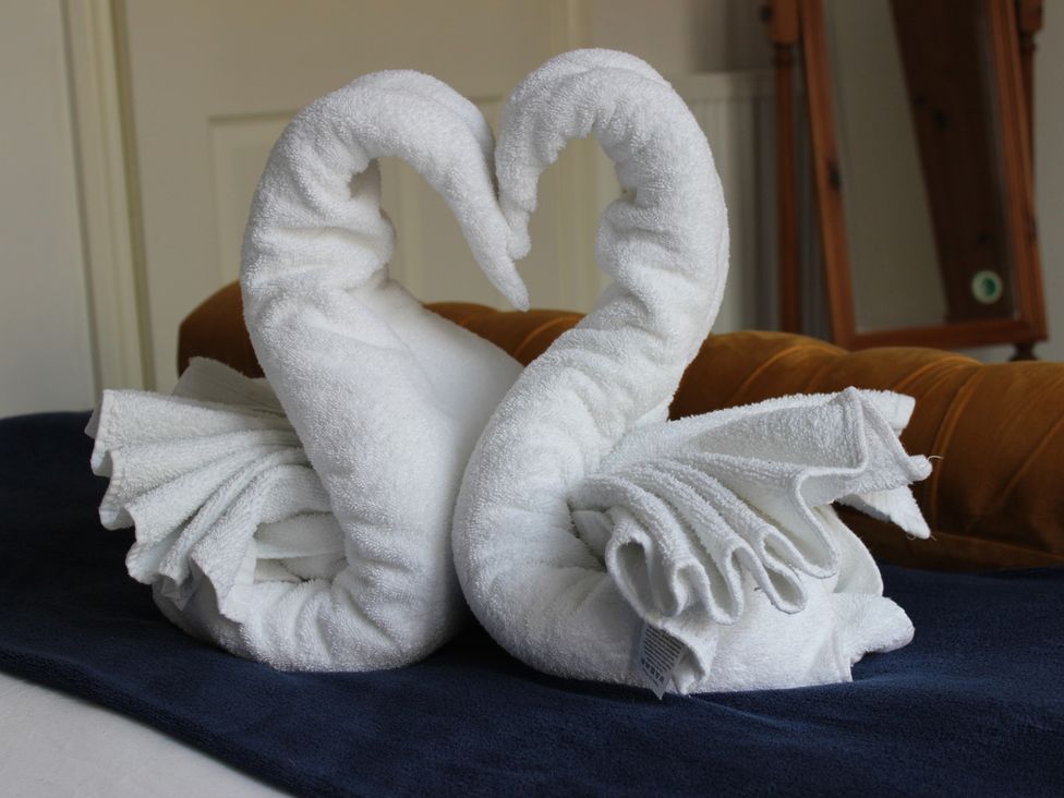 Two towel swans on a bed at Oliver Wests Apartment 1 in Scarborough