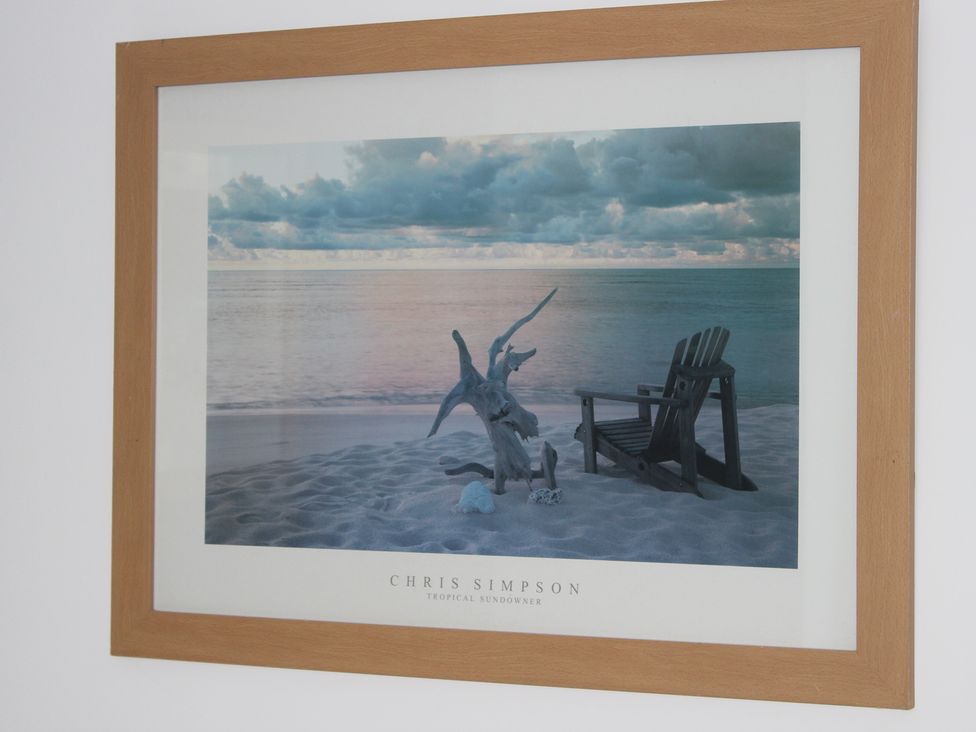 A framed photo of a beach scene at Oliver Wests Apartment 1 in Scarborough