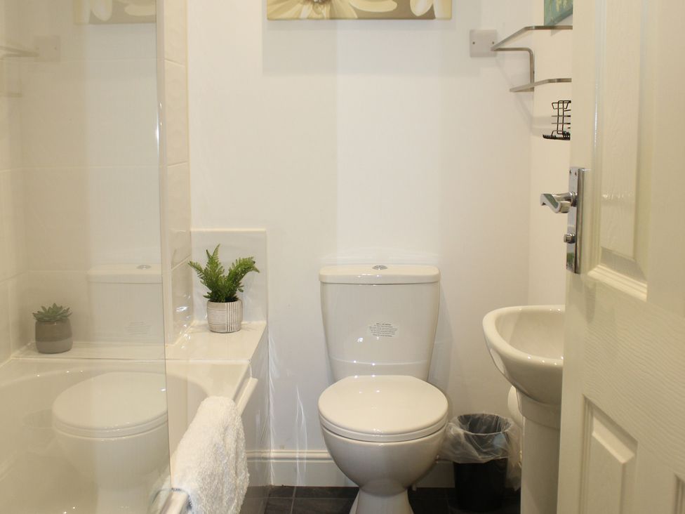 A bathroom with a toilet, sink, and shower at Oliver Wests Apartment 1 in Scarborough
