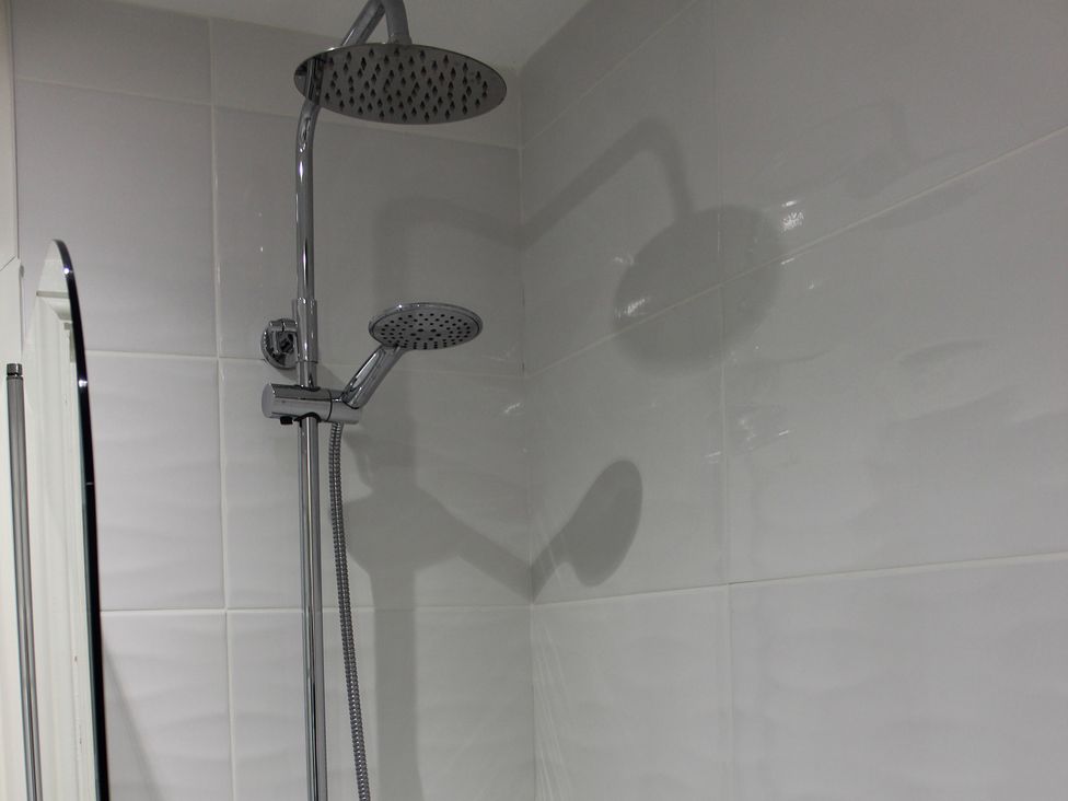 A shower setup with dual shower heads at Oliver Wests Apartment 1 in Scarborough