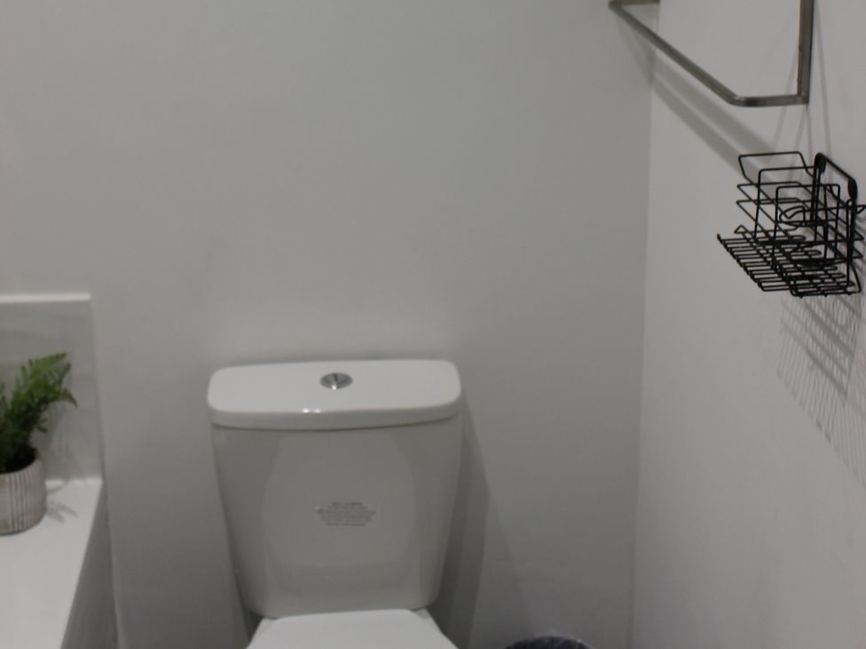 A bathroom with a toilet and plant at Oliver Wests Apartment 1 Scarborough
