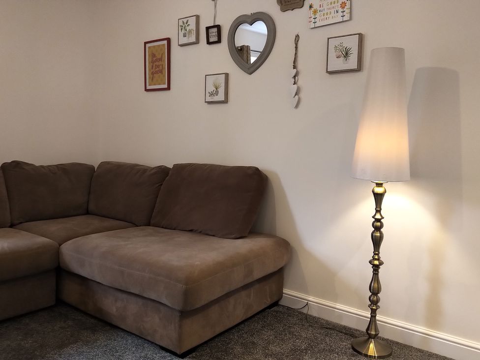 A living room with a sofa and a floor lamp at Oliver Wests Apartment 4 in Scarborough