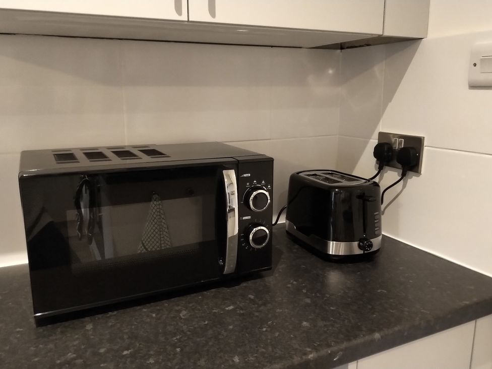 A kitchen with a microwave and toaster at Oliver Wests Apartment 4 in Scarborough
