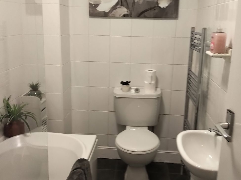A bathroom with a bathtub, toilet, and sink at Oliver Wests Apartment 4 in Scarborough