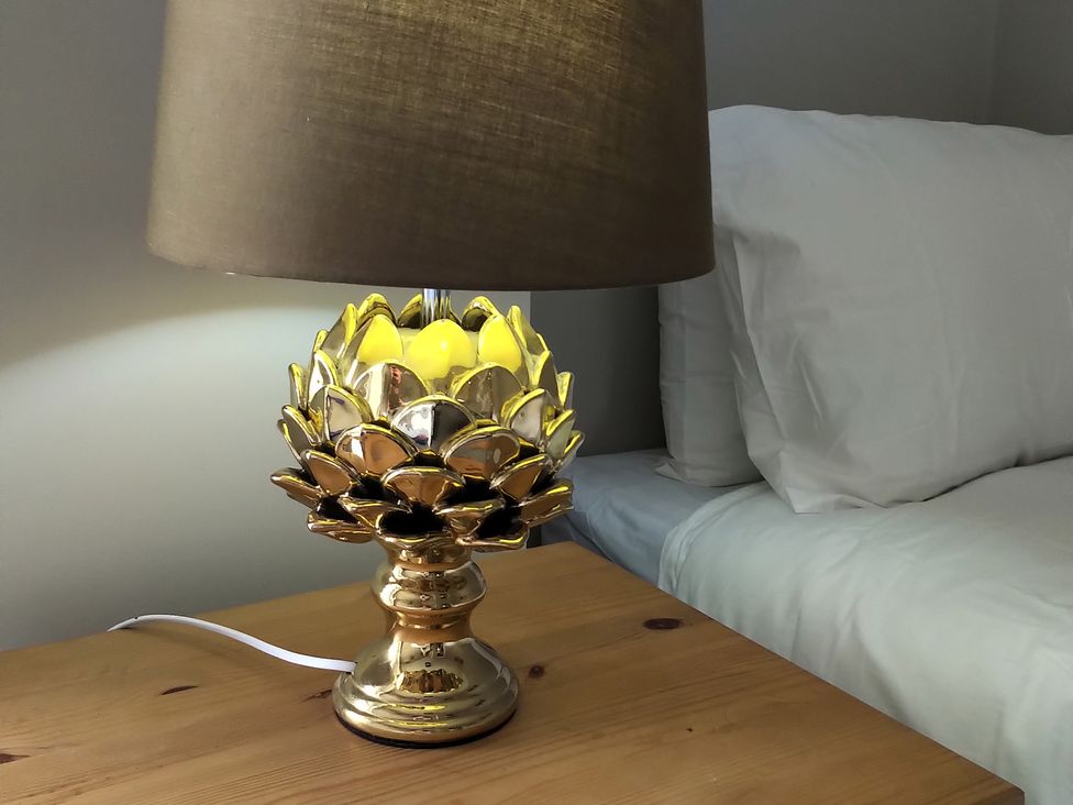 A lamp on a bedside table next to a bed at Oliver Wests Apartment 4 in Scarborough