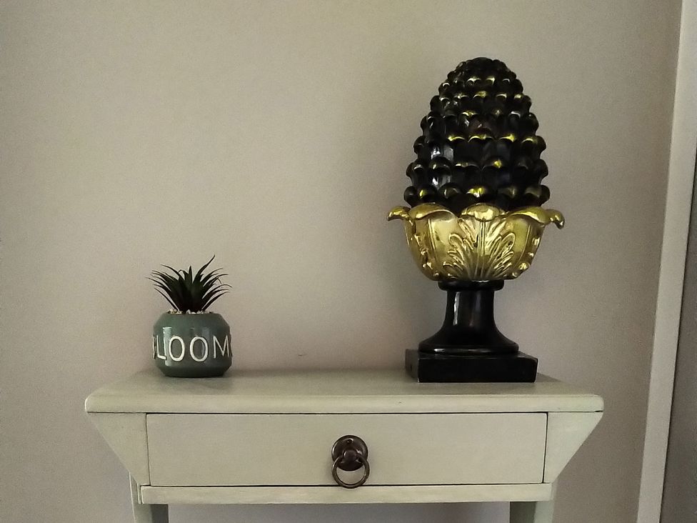 A table with a planter and an ornament in Oliver Wests Apartment 4 in Scarborough