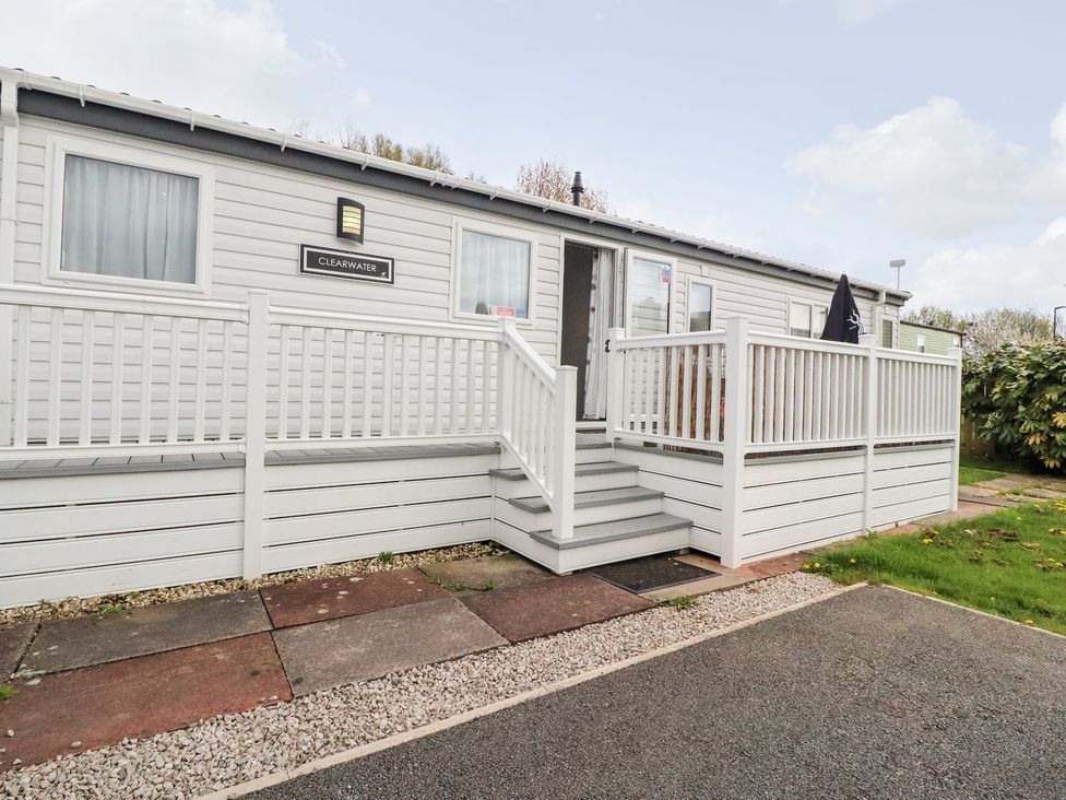 An outdoor view of a cabin with steps and a handrail at Clearwater in Morecambe