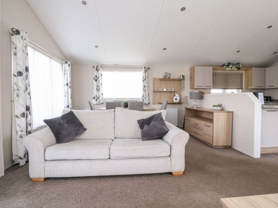 A living room with a sofa and dining area at Rosella 38 in Morecambe