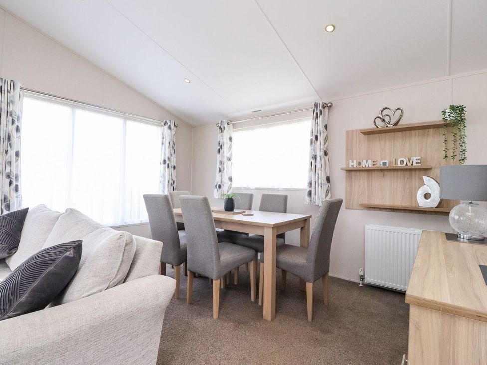 A dining room with a table and chairs at Rosella 38, Morecambe