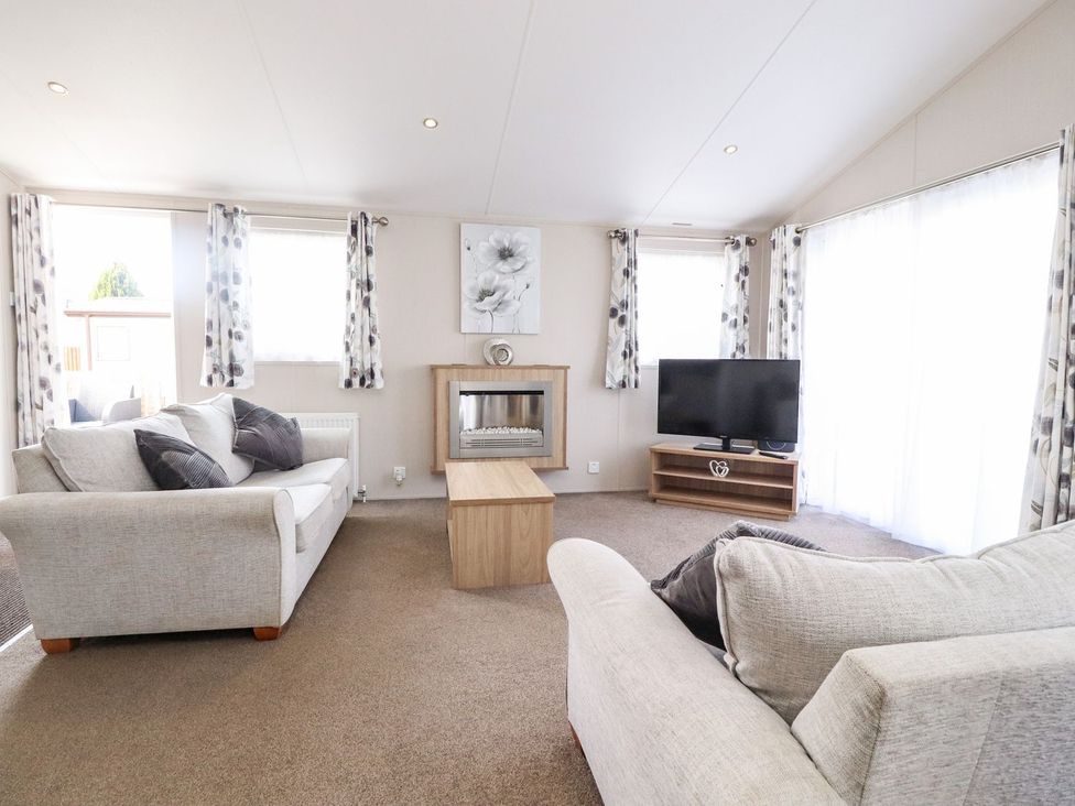 A living room with sofas and a television at Rosella 38 in Morecambe