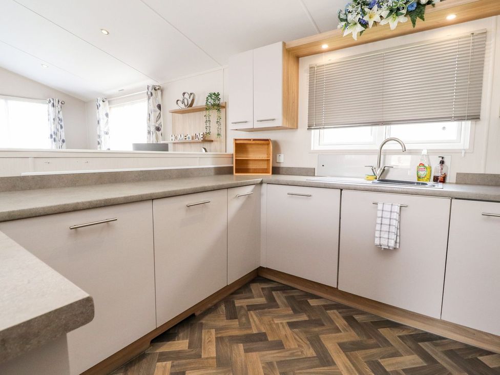 A kitchen with cabinets and a sink at Rosella 38 in Morecambe
