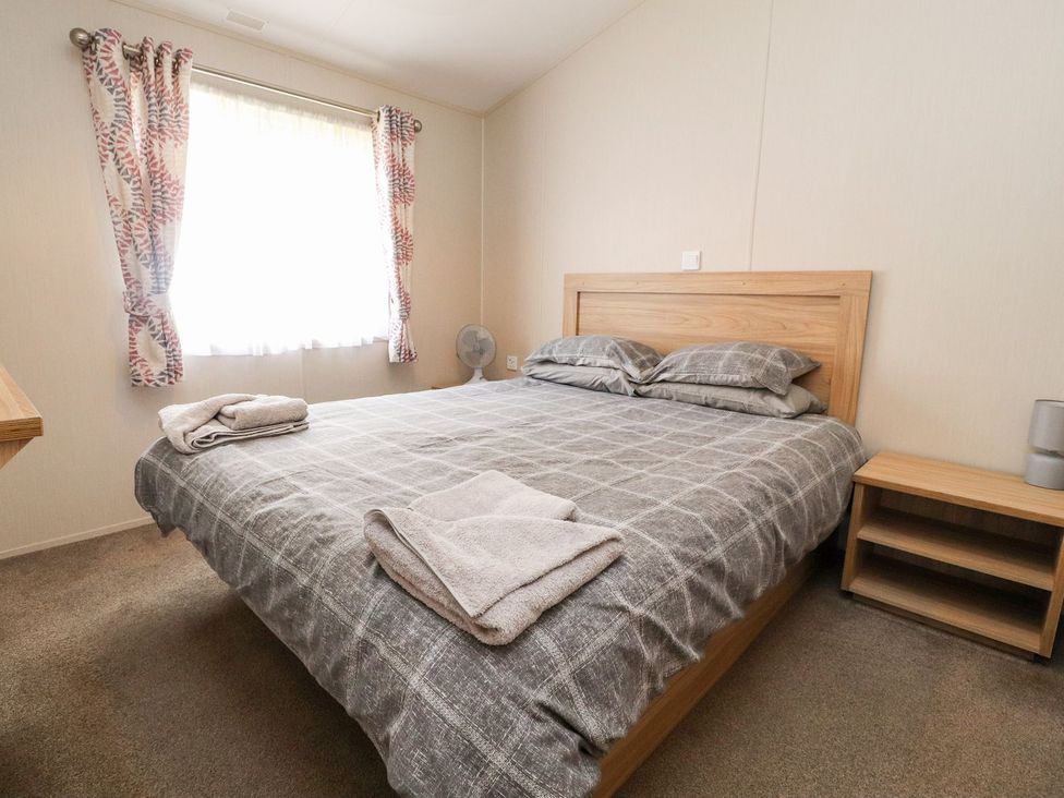 A bedroom with a bed and nightstand at Rosella 38 Morecambe