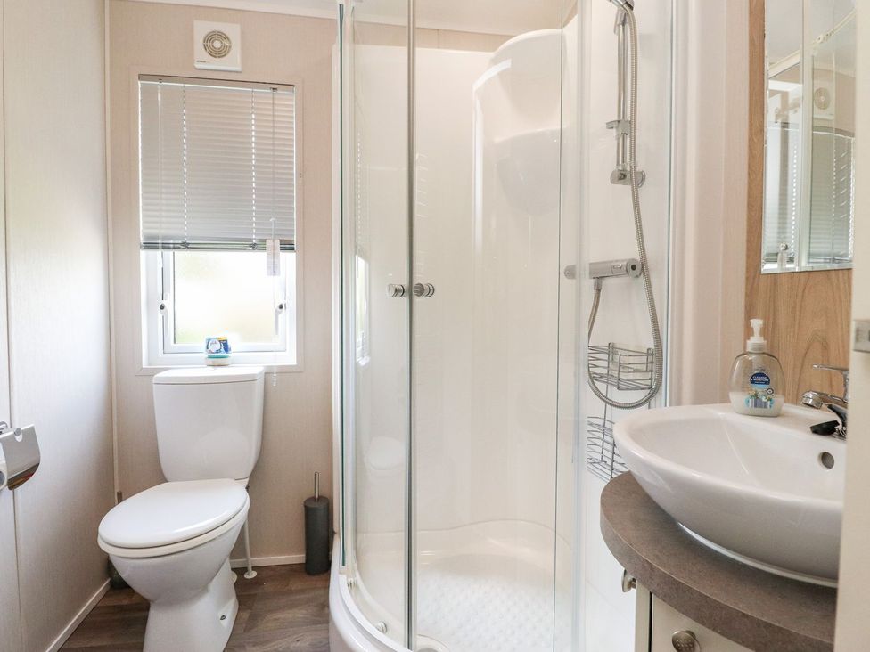 A bathroom with a shower, toilet, and sink at Rosella 38 Morecambe