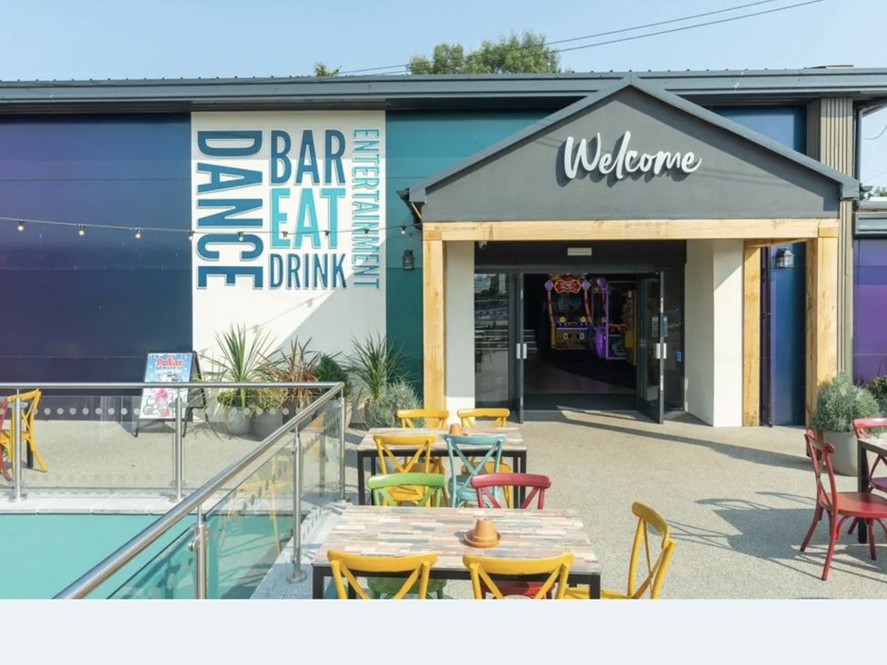 An outdoor seating area with tables and chairs at Golden Sands Holiday Park in Dawlish