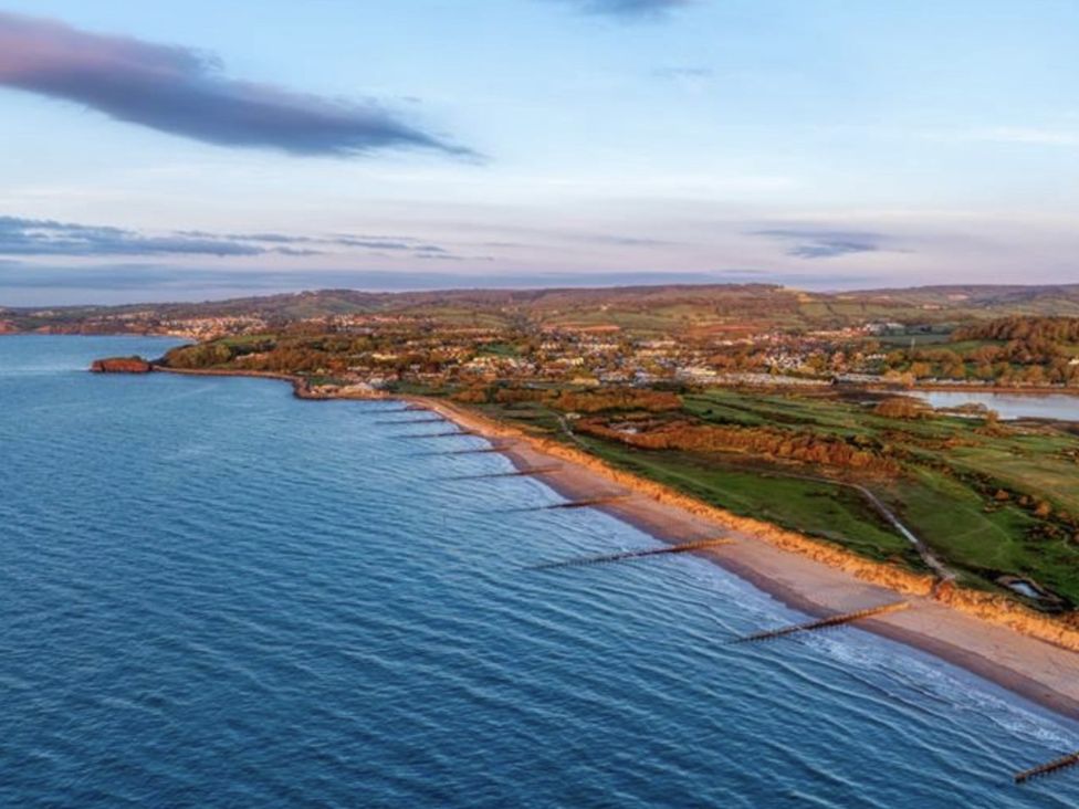 A coastal view showing a beach and hills at Golden Sands Holiday Park, Dawlish