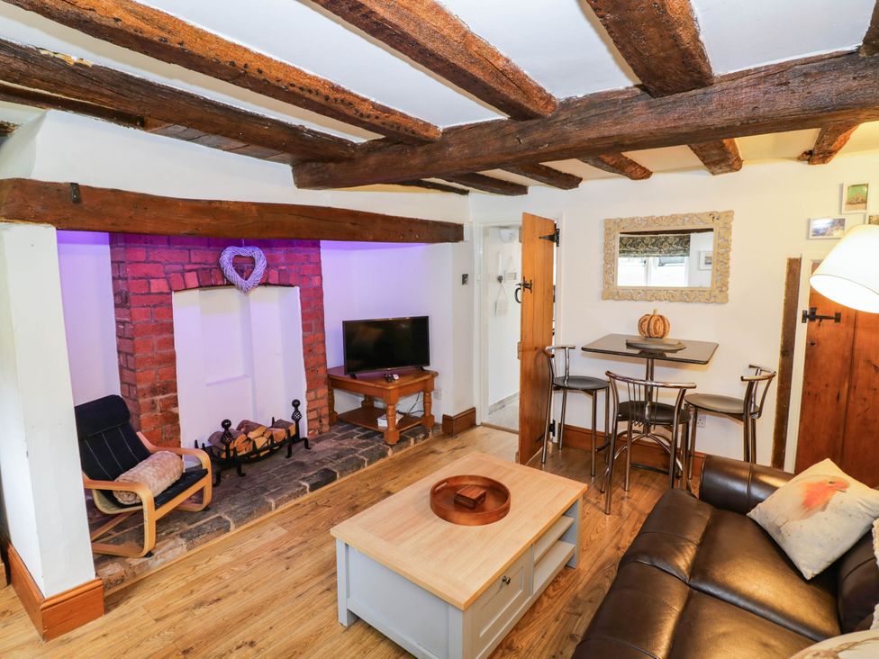 A living room with a sofa and television at Lilac Cottage in Brinklow