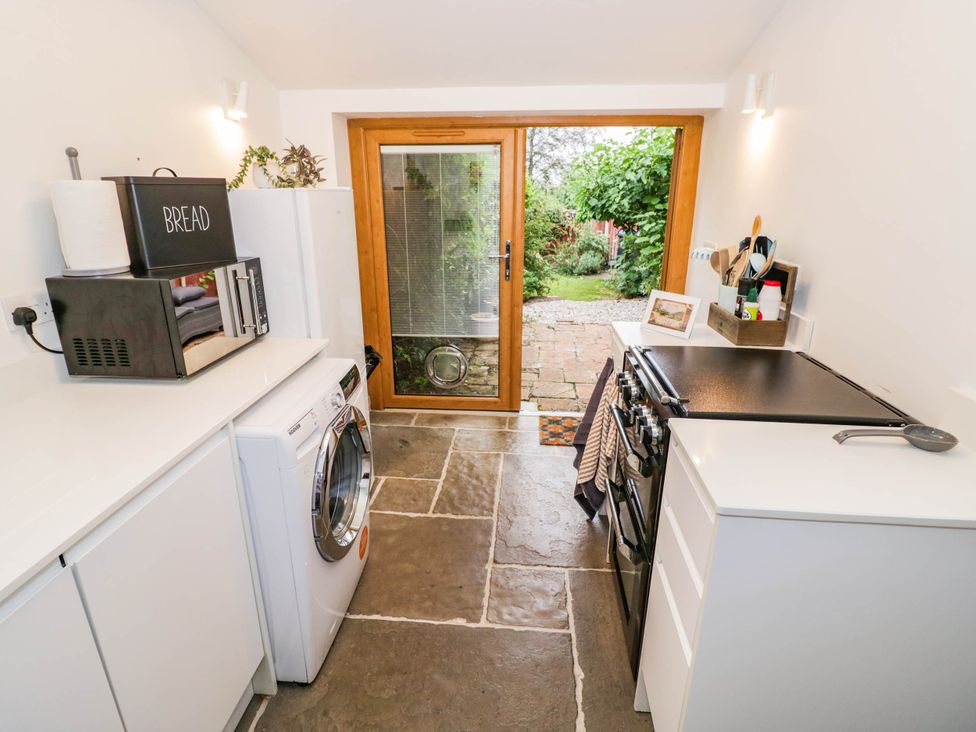 A kitchen with a washing machine and an oven at Lilac Cottage in Brinklow