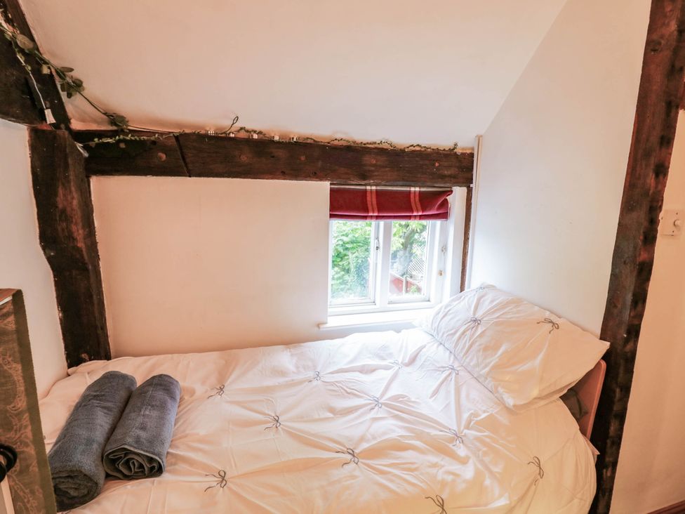 A bedroom with a bed and window at Lilac Cottage in Brinklow