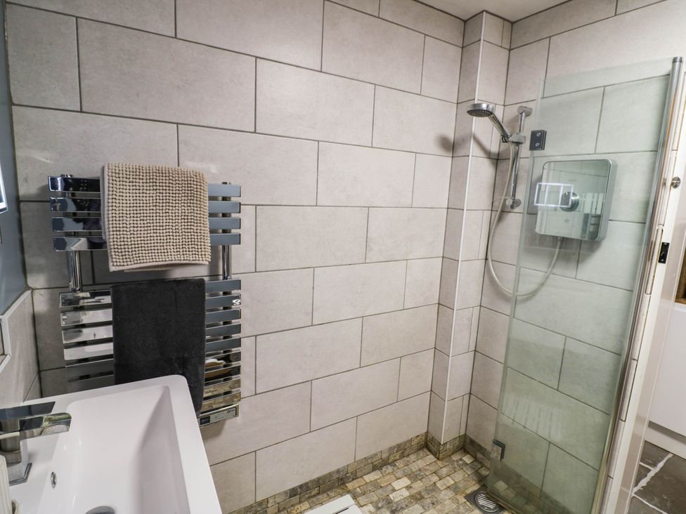 A bathroom with a shower and sink at Lilac Cottage in Brinklow