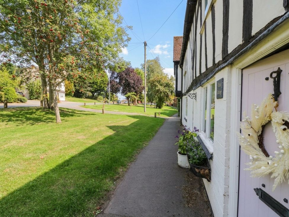 A pathway beside a building and trees at Lilac Cottage in Brinklow