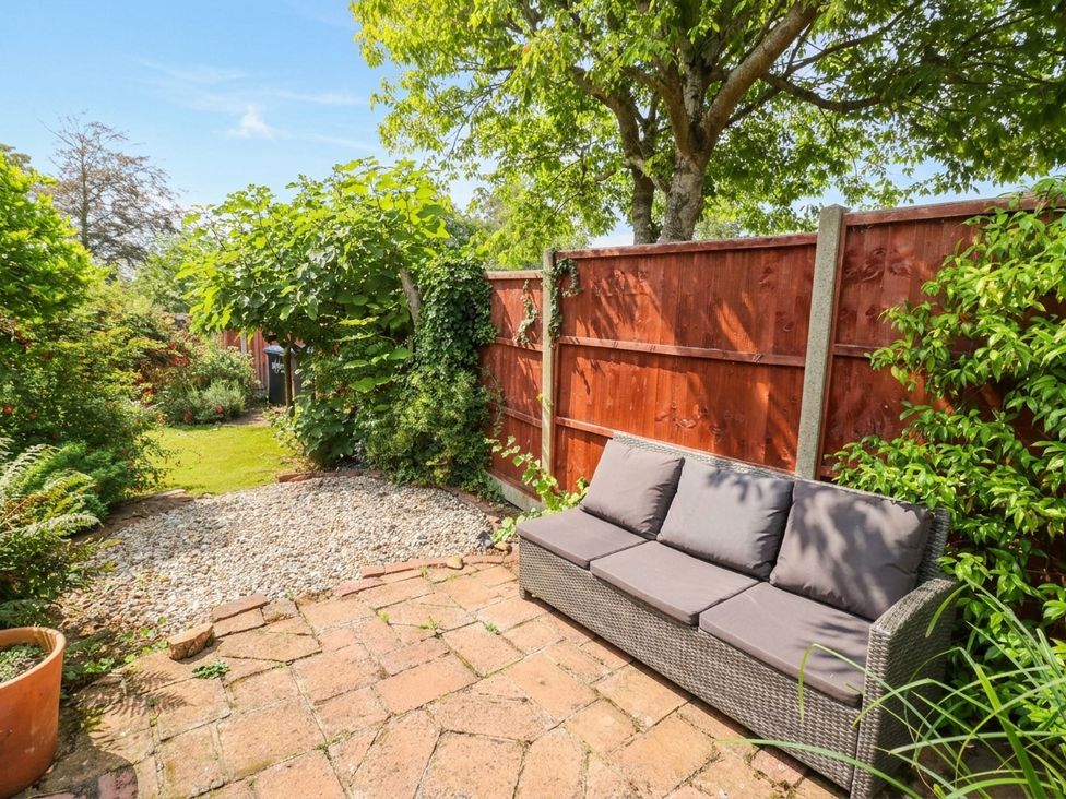 A garden with a sofa and gravel at Lilac Cottage in Brinklow
