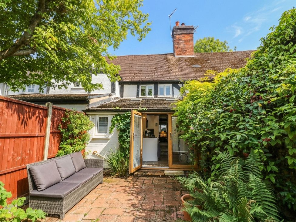 A garden with a sofa and a view of the house at Lilac Cottage in Brinklow
