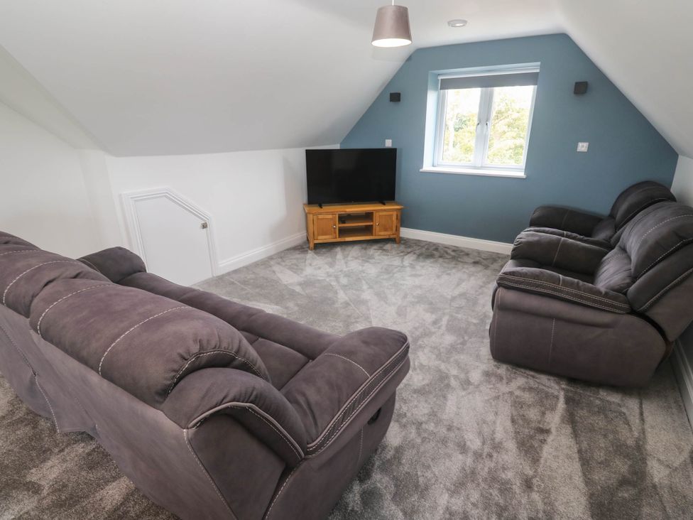 A living room with a sofa and television at 6 Coswinsawsin Lane near Camborne