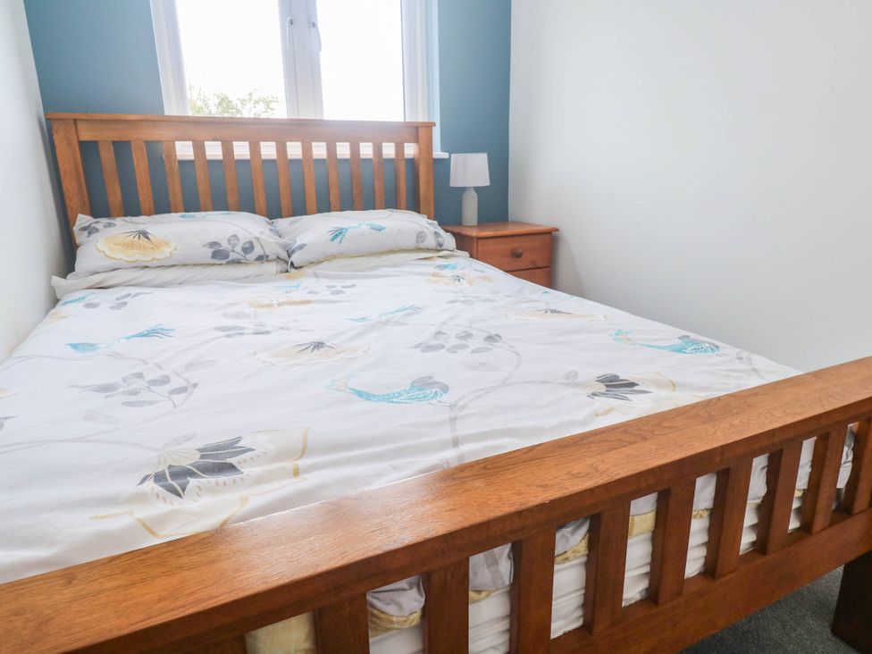 A bedroom with a bed and nightstand at 6 Coswinsawsin Lane near Camborne