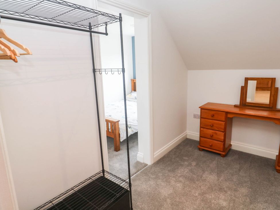 A bedroom with a clothes rack and a vanity table at 6 Coswinsawsin Lane near Camborne