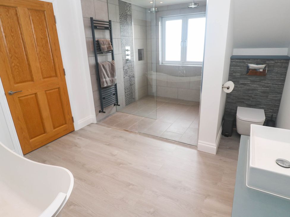 A bathroom with a shower, sink, and toilet at 6 Coswinsawsin Lane near Camborne