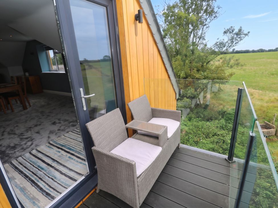 A balcony with chairs and a table at 6 Coswinsawsin Lane near Camborne