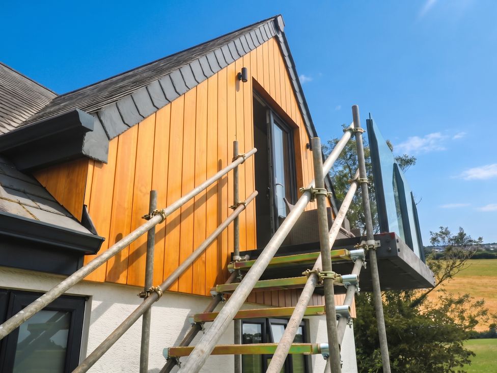 A house exterior with scaffolding and wooden wall at 6 Coswinsawsin Lane near Camborne