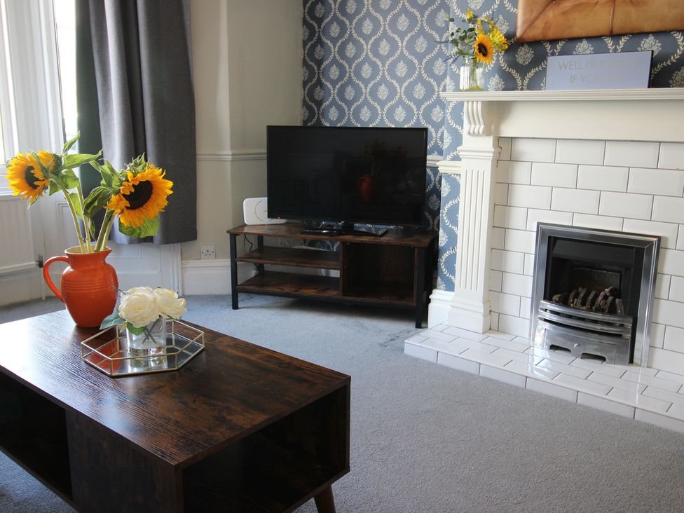 A living room with a coffee table and tv at The Hampton in Scarborough