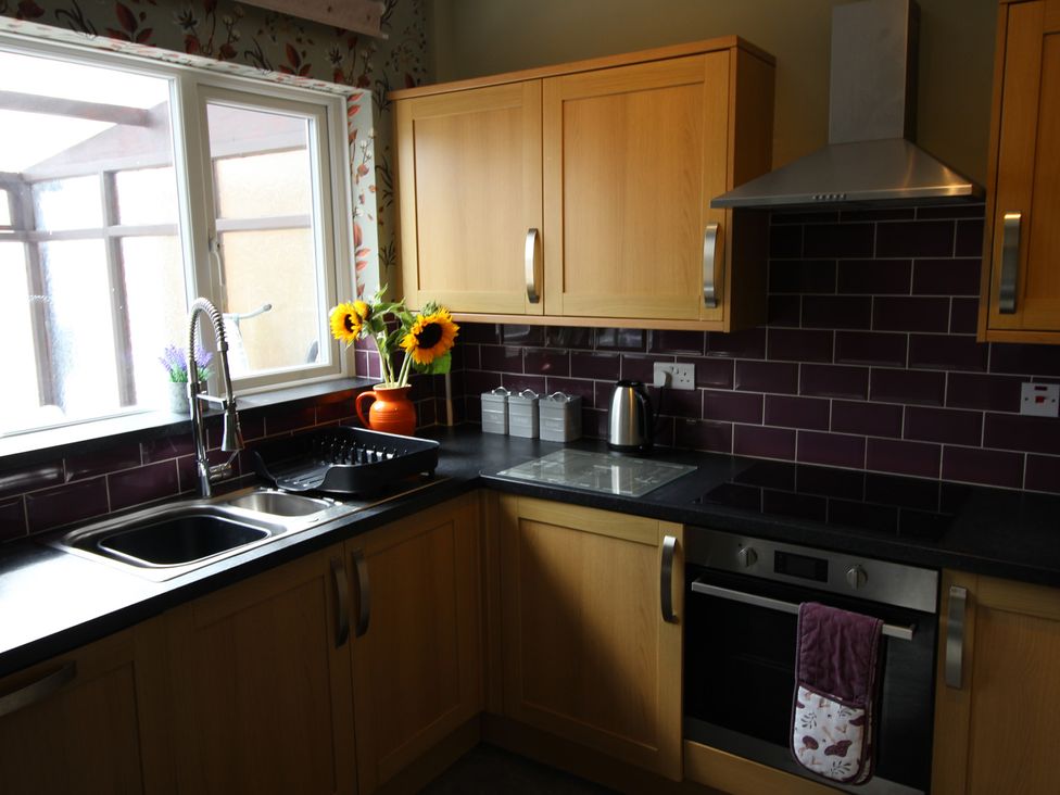 A kitchen with sink, oven and flowers at The Hampton in Scarborough