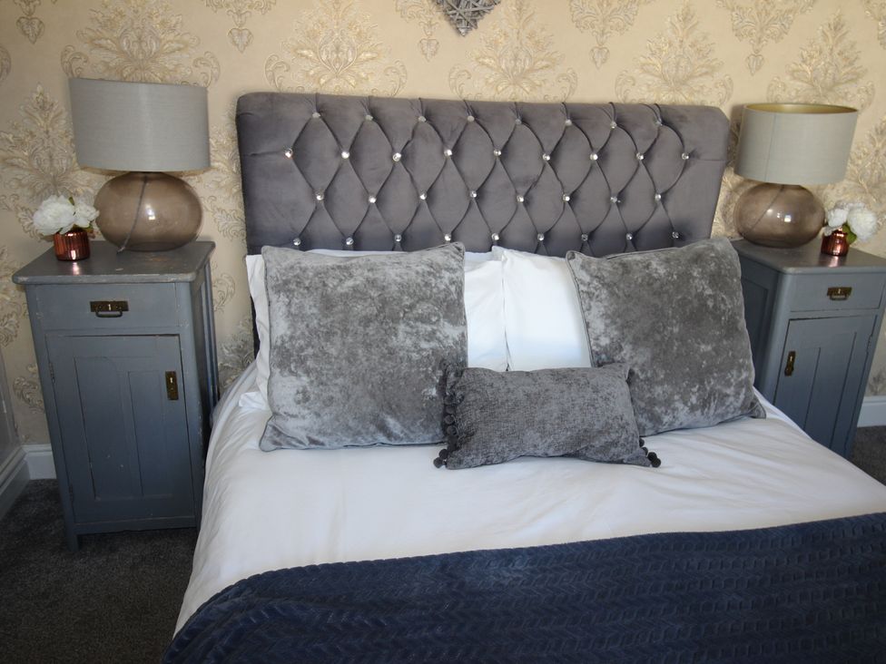 A bedroom with a bed and nightstands at The Hampton in Scarborough