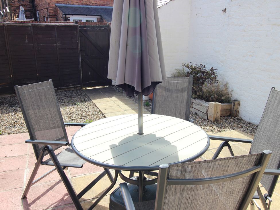 A garden with a table and chairs under an umbrella at The Hampton in Scarborough