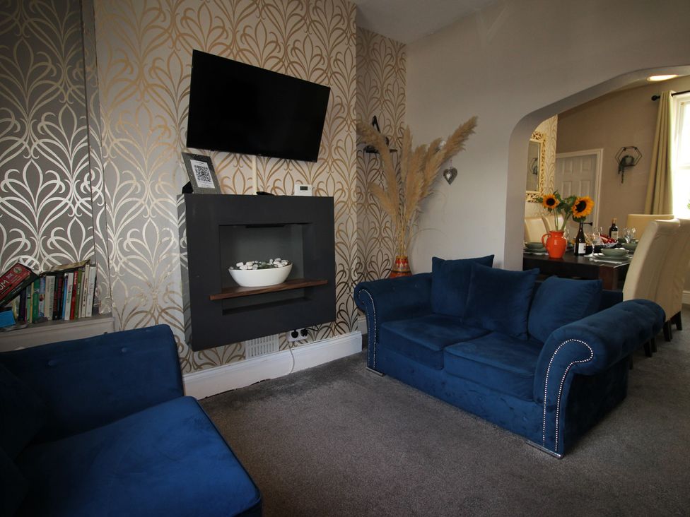 A living room with a television and a sofa at The Trafalgar in Scarborough