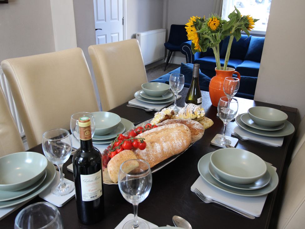 A dining room set with plates and wine glasses at The Trafalgar in Scarborough